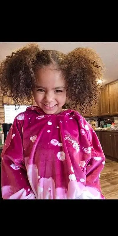 Face, Smile, Facial Expression, Purple, Jheri Curl, Sleeve, Dress, Happy, Pink, Baby & Toddler Clothing, Ringlet, Fashion Design, Magenta, Child, Toddler, Entertainment, Fun, Event, Formal Wear, Fashion Accessory, Person, Joy