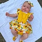 Face, Skin, Head, Eyes, Dress, Baby & Toddler Clothing, Textile, Sleeve, Happy, Baby, Toddler, Smile, Grass, Child, Fun, Pattern, People In Nature, T-shirt, Leisure, Linens, Person, Headwear