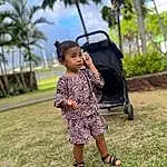 Plant, Sky, Smile, Tree, Leaf, People In Nature, Dress, Happy, Grass, Leisure, Travel, Black Hair, Grassland, Toddler, Recreation, Sneakers, Sandal, Child, Landscape, Palm Tree, Person