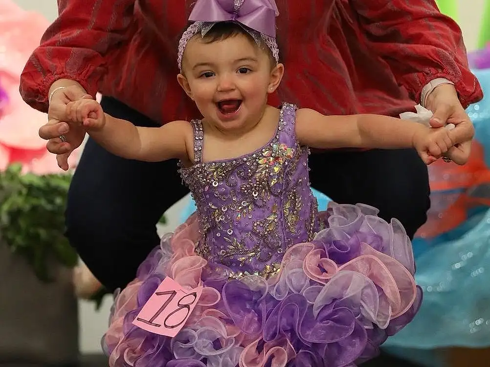 Clothing, Footwear, Shoe, Smile, Photograph, Facial Expression, Purple, Entertainment, Happy, Pink, Dress, Gesture, Performing Arts, Hat, Plant, Leisure, Recreation, Toddler, Sneakers, People, Person, Joy