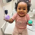 Smile, Cheek, Joint, Skin, Head, Hand, Arm, Eyes, Purple, Sleeve, Iris, Gesture, Pink, Thumb, Finger, Happy, Toddler, Baby, Picture Frame, Room, Person, Joy