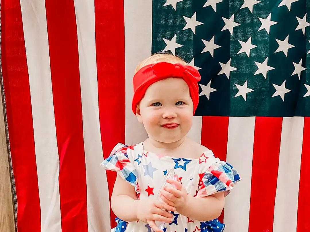 Face, Smile, Flag Of The United States, Baby & Toddler Clothing, Textile, Sleeve, Happy, Baby, Red, Hat, Flag Day (usa), Toddler, Costume Hat, Pattern, Event, Flag, Holiday, Cap, Electric Blue, Design, Person, Joy, Headwear