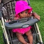 Photograph, Facial Expression, Tire, Green, Baby Carriage, Comfort, Pink, Grass, Toddler, Chair, Wheel, Cap, Baby & Toddler Clothing, Red, Leisure, Magenta, Baby, Lawn, Person, Surprise, Headwear
