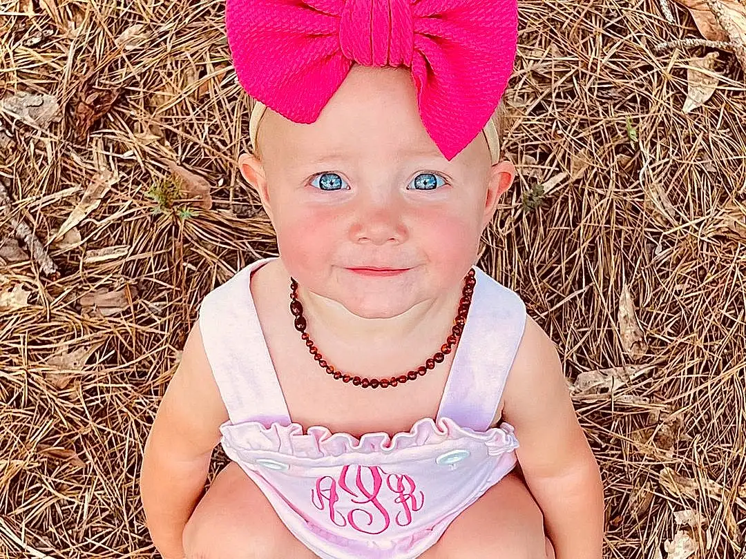 Face, Head, Eyes, People In Nature, Baby & Toddler Clothing, Happy, Grass, Toddler, Baby, Headband, Headpiece, Magenta, Pattern, Petal, Fashion Accessory, Child, Fun, Hair Accessory, Portrait Photography, Person, Joy, Headwear
