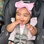 Cheek, Skin, Hand, Outerwear, Eyes, Facial Expression, White, Comfort, Baby, Gesture, Baby & Toddler Clothing, Pink, Seat Belt, Finger, Baby In Car Seat, Toddler, Cool, Person, Headwear