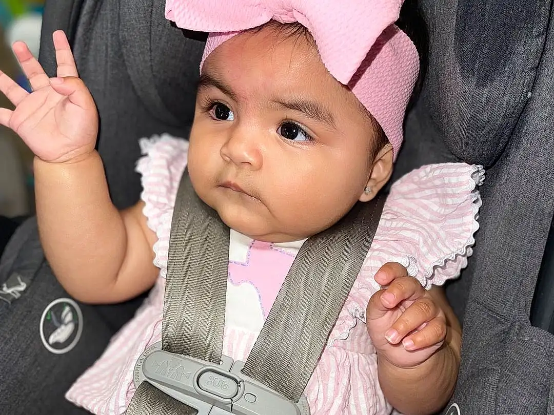 Cheek, Skin, Lip, Chin, Hand, Hairstyle, Seat Belt, Mouth, Comfort, Baby & Toddler Clothing, Human Body, Sleeve, Baby, Finger, Gesture, Cap, Baby Carriage, Pink, Thumb, Toddler, Person, Headwear