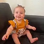 Face, Cheek, Smile, Skin, Joint, Head, Shoulder, Arm, Eyes, Facial Expression, Baby & Toddler Clothing, Human Body, Neck, Sleeve, Couch, Iris, Dress, Finger, Person, Joy