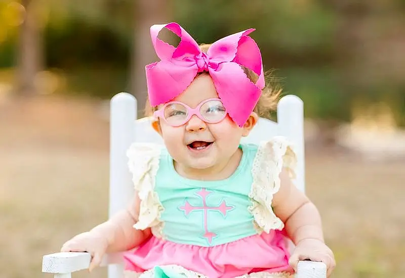 Face, Glasses, Head, Skin, Smile, Happy, Dress, Baby & Toddler Clothing, Baby, Pink, Eyewear, Headgear, Grass, Toddler, Fun, Headpiece, Party Supply, Headband, Recreation, Event, Person, Headwear