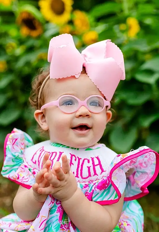 Glasses, Skin, Head, Lip, Smile, Hand, Photograph, Facial Expression, Green, Plant, Happy, Yellow, Grass, People In Nature, Pink, Baby & Toddler Clothing, Cap, Toddler, Baby, Red, Person