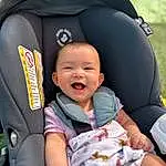 Skin, Smile, White, Comfort, Gesture, Finger, Baby, Toddler, Happy, Child, Baby Carriage, Baby & Toddler Clothing, Baby Products, Fun, Auto Part, Baby In Car Seat, Event, Car Seat, Sitting, Head Restraint, Person