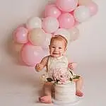 Head, Smile, Balloon, Dress, Happy, Gesture, Pink, Baby & Toddler Clothing, Party Supply, Baby, Toddler, Child, Event, Sweetness, Magenta, Flash Photography, Fun, Peach, Pattern, Party, Person, Joy
