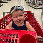 Smile, Vehicle, Shelf, Vroom Vroom, Toddler, Leisure, Fun, Happy, Child, Recreation, Retail, Baby & Toddler Clothing, Shopping Cart, Automotive Design, Customer, Sitting, Magenta, Convenience Store, Play, Baby, Person, Joy