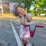 Shorts, Smile, Plant, Asphalt, Tire, Dress, Happy, Tree, Pink, Road Surface, Leisure, Toddler, Kick Scooter, Sneakers, Road, Recreation, Toy, Electric Blue, Grass, Fun, Person, Joy
