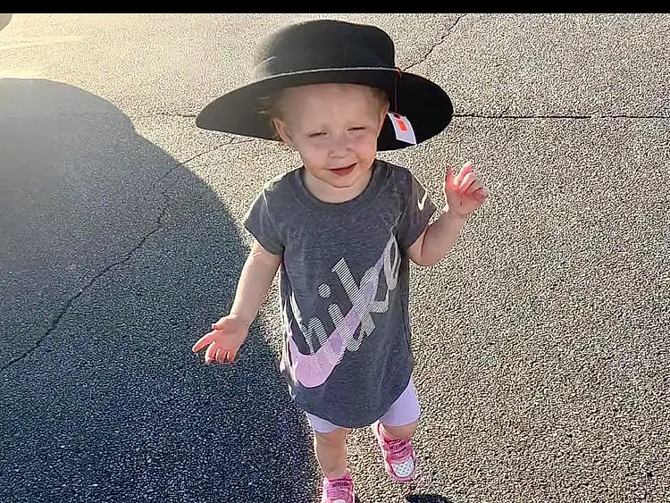 Smile, Hat, Sleeve, Gesture, Asphalt, Happy, Road Surface, Cool, Toddler, People In Nature, T-shirt, Tints And Shades, Sun Hat, Tar, Child, Sidewalk, Soil, Road, Fun, Person, Joy, Headwear