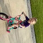 Face, Tire, Wheel, Bicycle, Plant, Dress, Bicycle Tire, Tree, Pink, Bicycle Wheel, Toddler, Leisure, Recreation, People In Nature, Happy, Bicycle Handlebar, Magenta, Fun, Grass, Bicycle Frame, Person, Joy