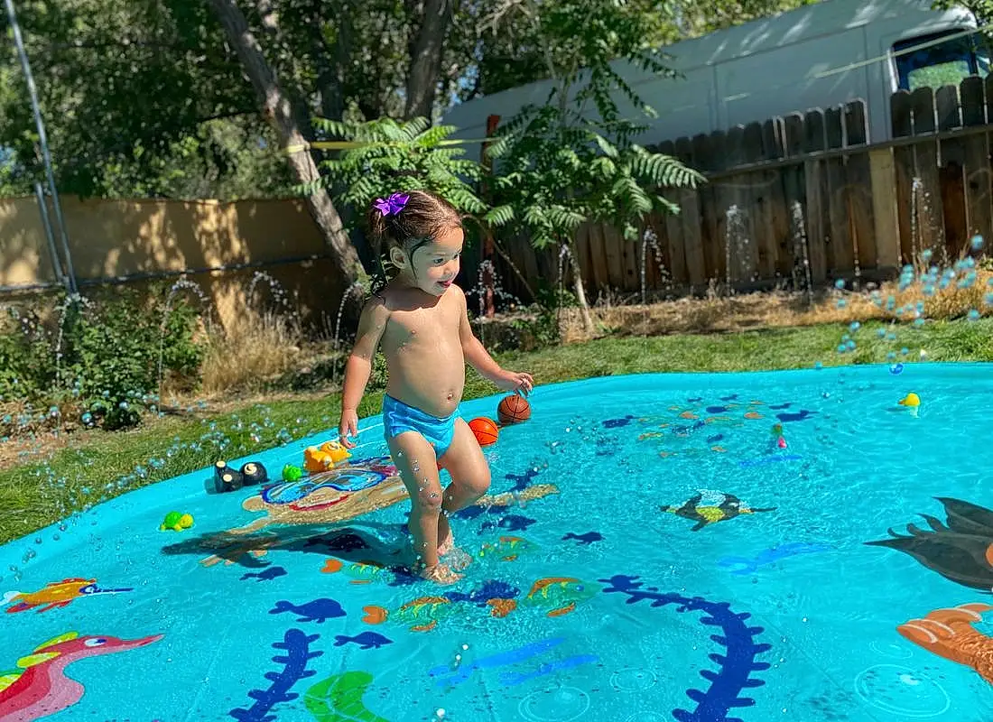 Water, Plant, Tree, Swimwear, Toy, Grass, Leisure, Toddler, Recreation, Swimming Pool, Fun, People In Nature, Electric Blue, Barefoot, Bathing, Games, Child, Play, Garden, Vacation, Person
