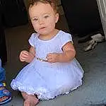 Head, Hairstyle, White, Baby & Toddler Clothing, Sleeve, Dress, Flash Photography, Toddler, Day Dress, Baby, Embellishment, Human Leg, Child, Foot, Happy, Sitting, Event, Barefoot, Fun, Person